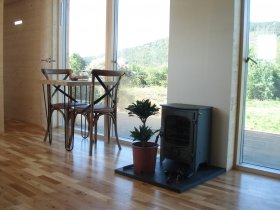 An image showing the interior and wood burning stove at Loch Ken Eco Bothies self catering accommoda